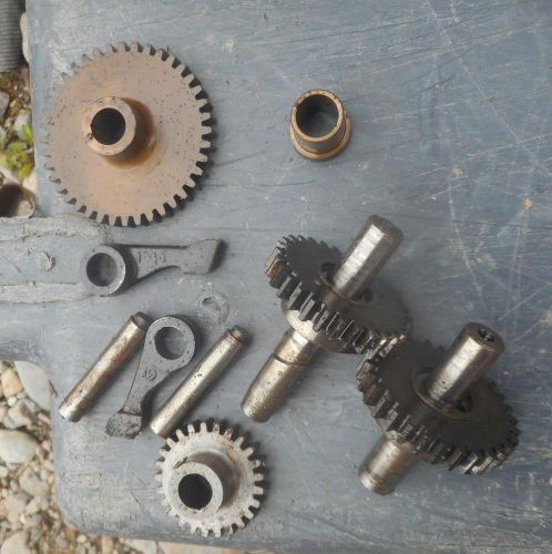 Parts for a vintage gas-powered hit-and-miss engine, modeled after the Norman SC type, with gear components.